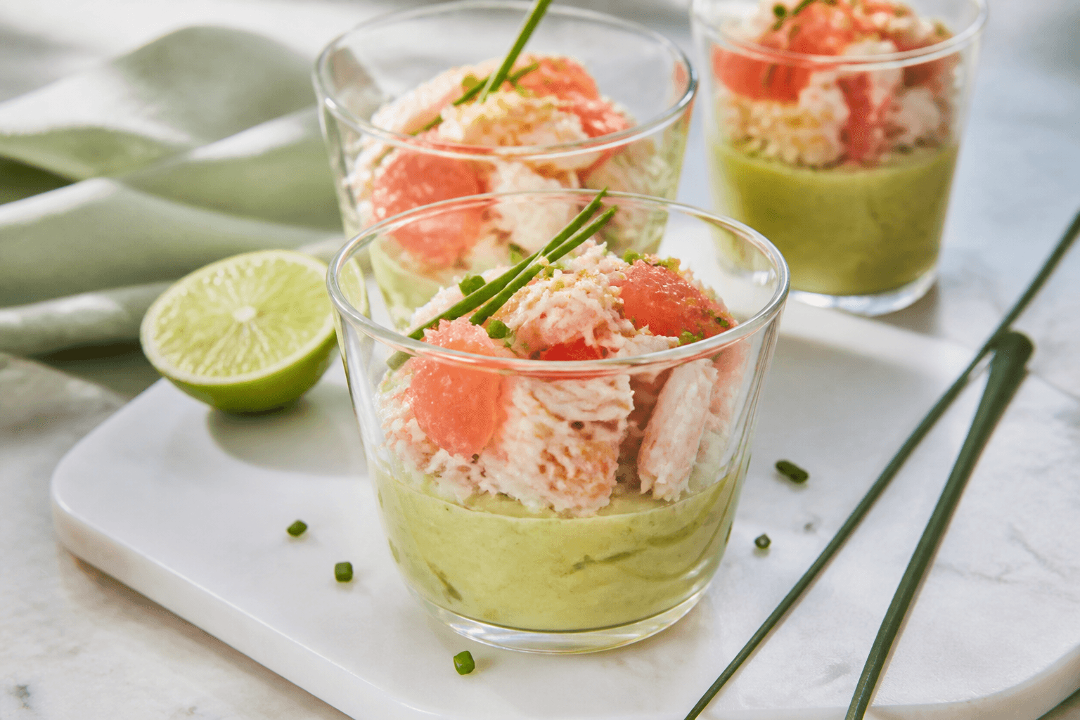 Verrines de mousse avocat avec crabe effiloché, pamplemousse rose et ciboulette.