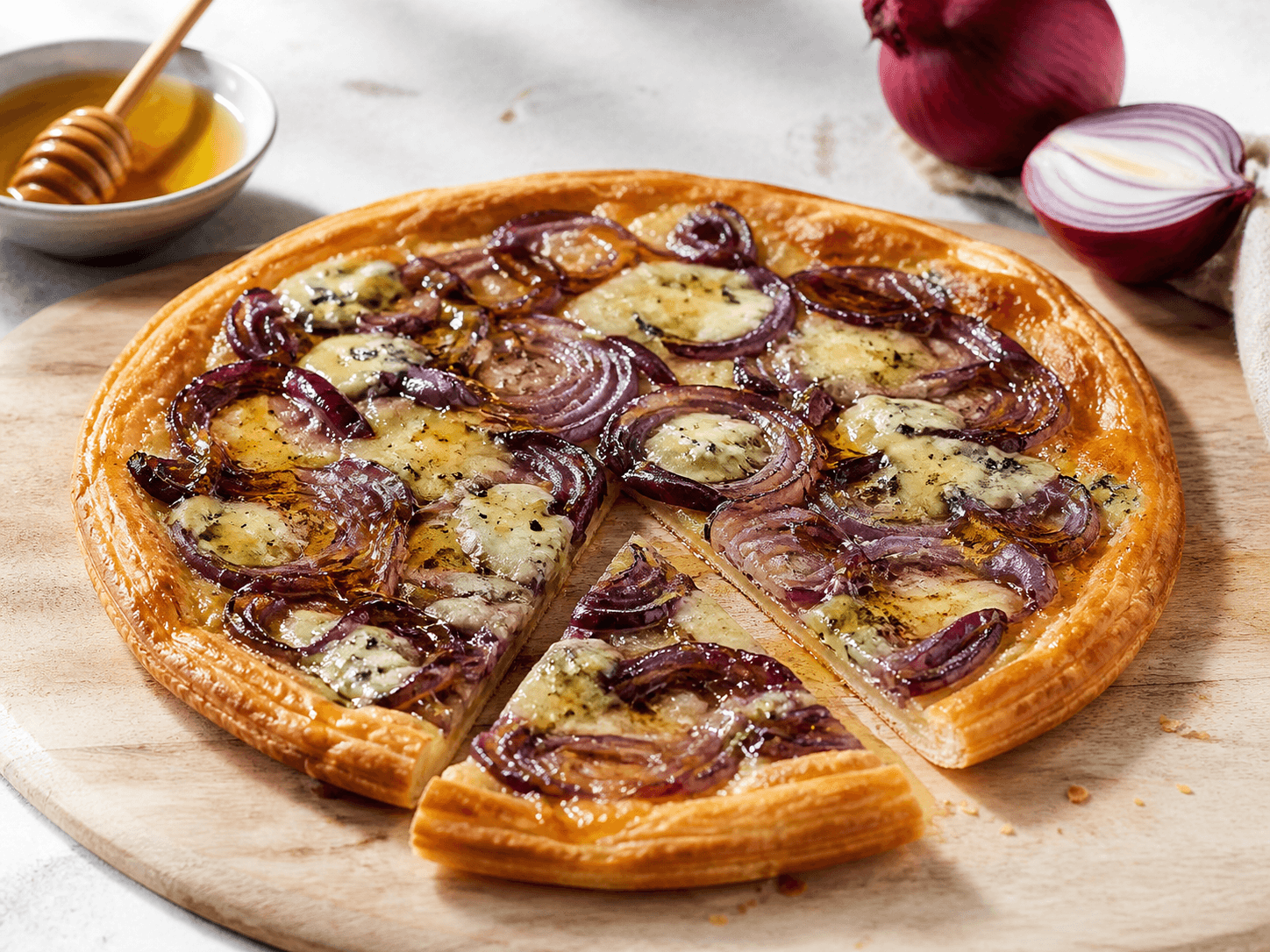Tarte fine à l'oignon rouge, bleu et miel, plat terminé présenté naturellement